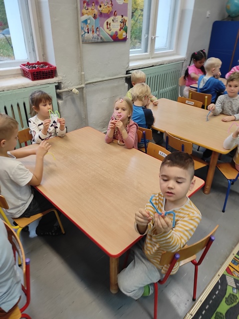 Dzieci przy stolikach, z drucików kreatywnych tworzą literę "M"