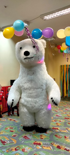 Człowiek w kostiumie ogromnego białego niedźwiedzia.
